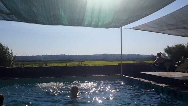 A swimming pool with a view of a green landscape and a clear sky. - Termas da Azenha (Soure)