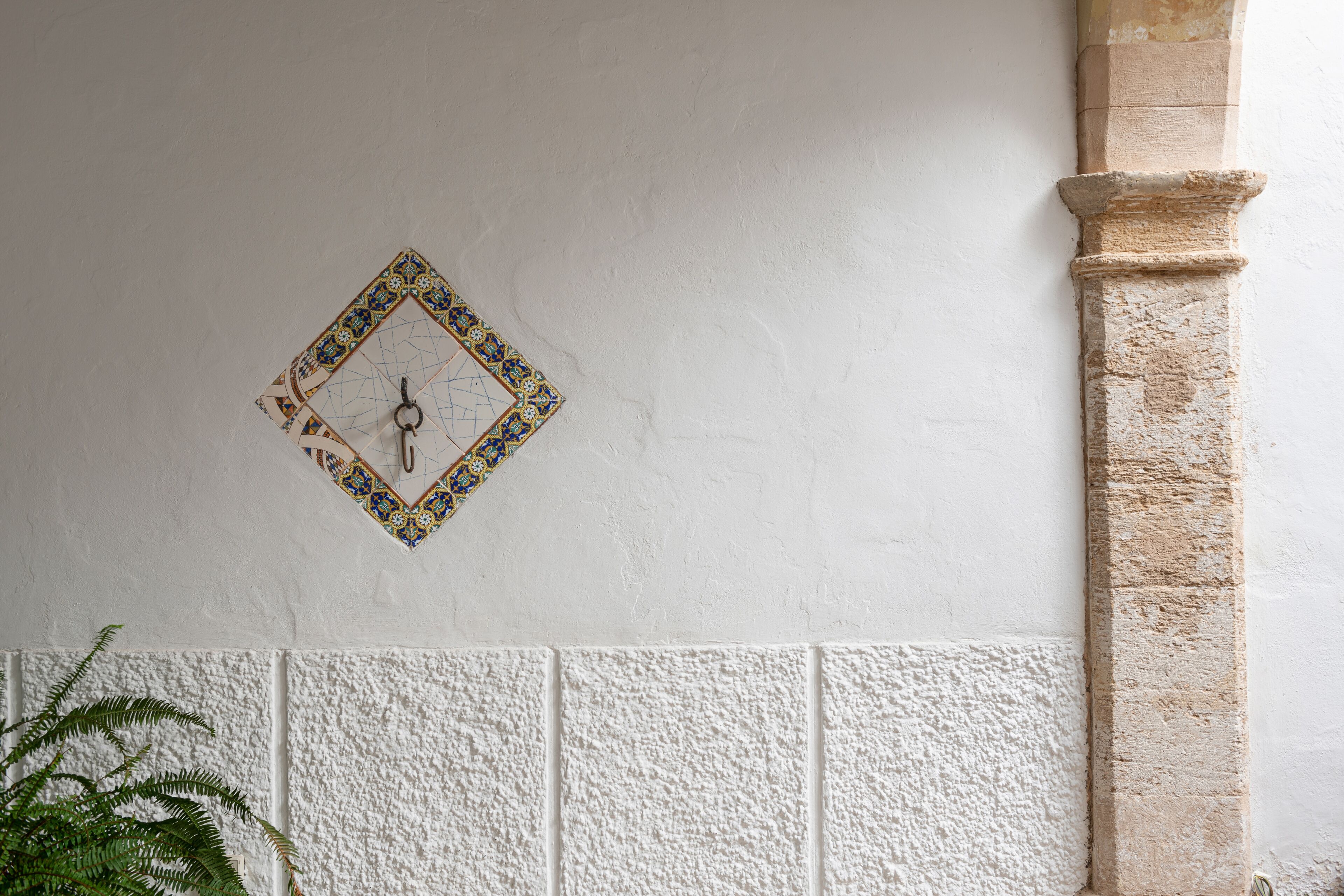 Een muur met een decoratieve klok en een reliëf paneel eronder.