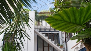 A modern building with a staircase leading to a balcony with potted plants. - Hostal Pons (Palma de Mallorca)