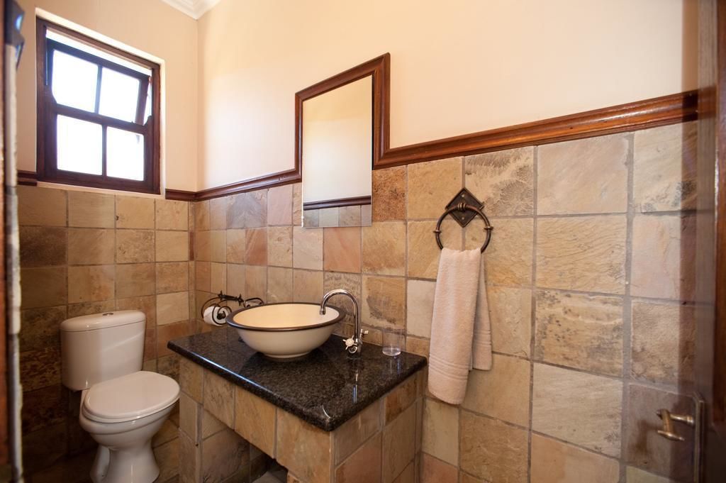 Un baño con inodoro, lavabo y espejo.