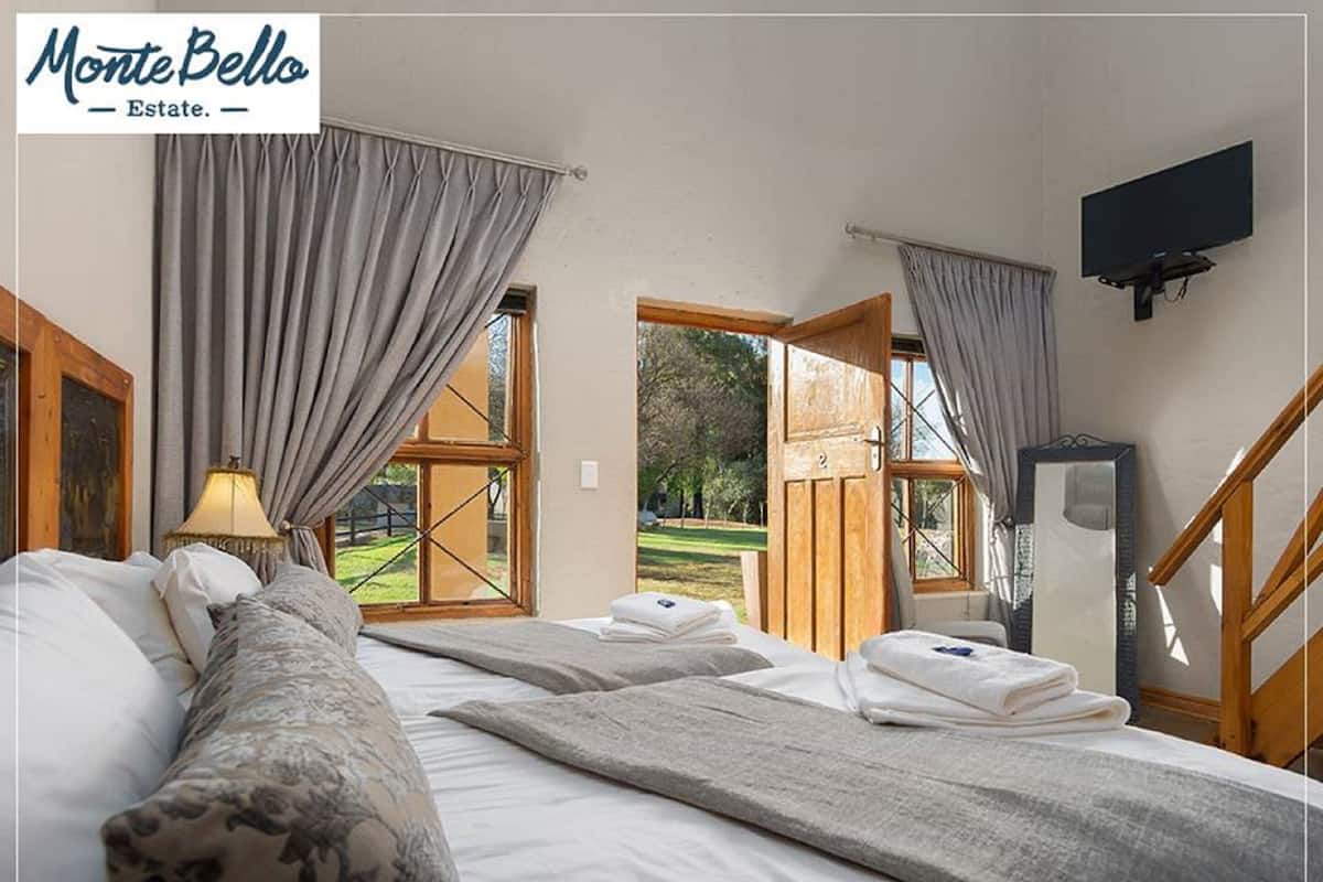 Ein Hotelzimmer mit Bett, Fernseher und Blick ins Freie.