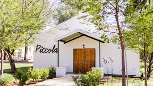 Un edificio con una puerta de madera y un letrero que dice "Piccola".