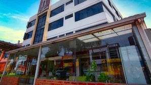 Un hotel con fachada moderna, grandes ventanales y un letrero llamativo.