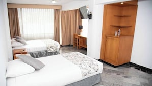 Una habitación de hotel con dos camas, un escritorio y un armario.