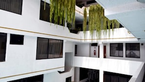 Un edificio de varios niveles con balcones y plantas colgantes.