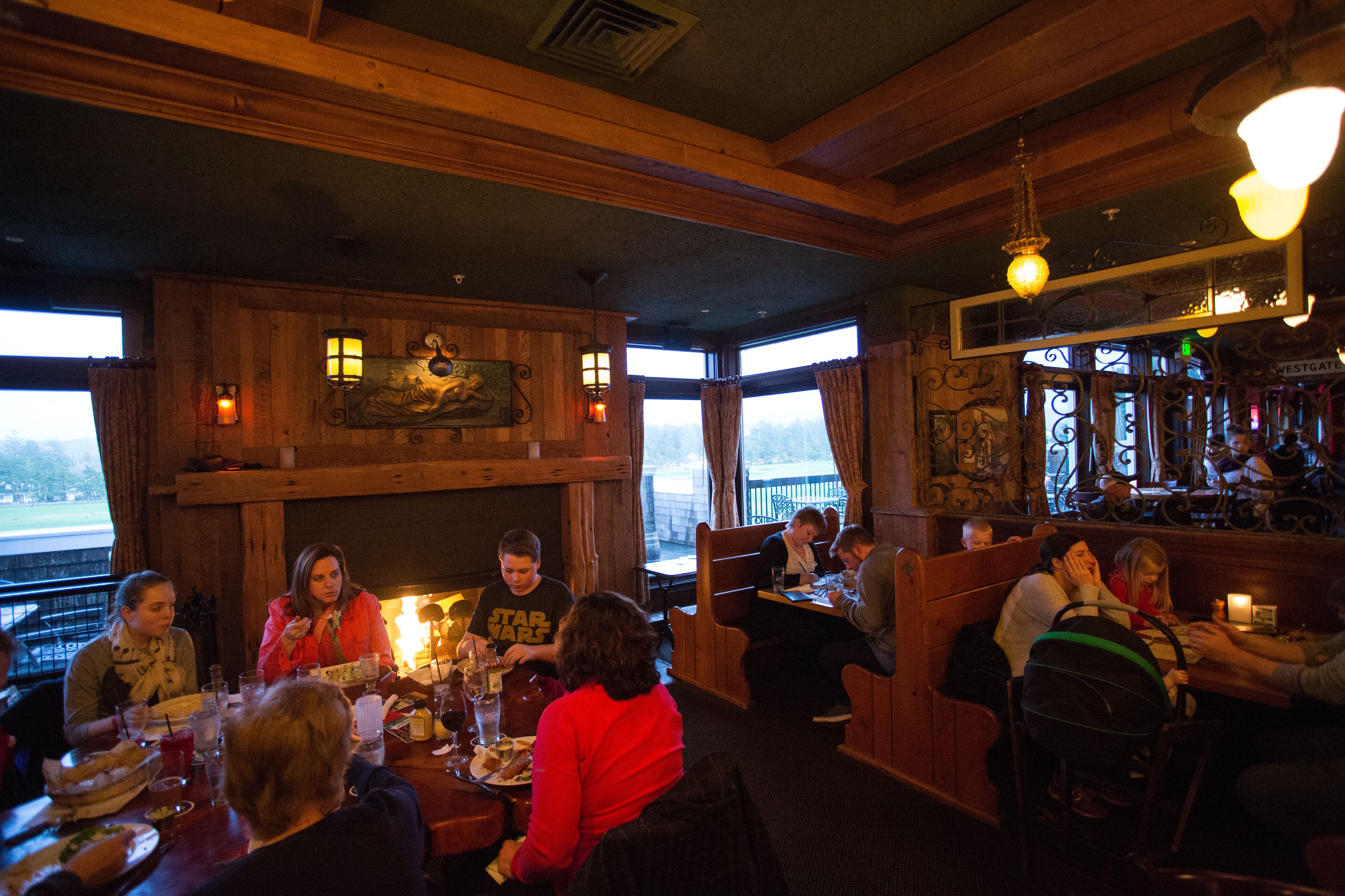 Un restaurant au décor intérieur en bois, doté de nombreuses tables et offrant une vue sur l’extérieur.