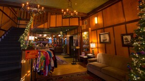 A hotel lobby with a staircase, a bar area, a Christmas tree, and a sofa. - McMenamins Gearhart Hotel (Gearhart)