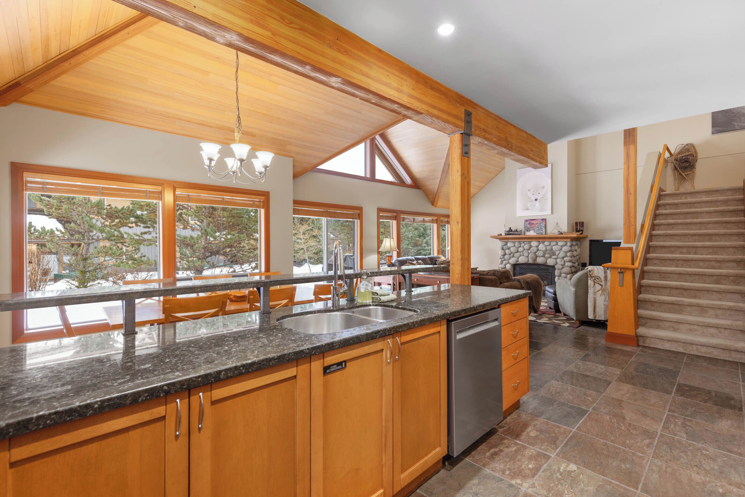 A spacious kitchen with wooden cabinets, granite countertops, and a built-in dishwasher.