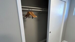 Ein begehbarer Kleiderschrank mit einem Wäscheständer aus Holz und einer Tür.