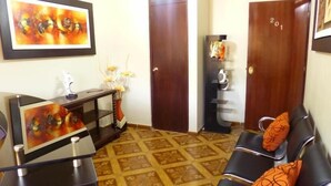 Una habitación con escritorio, una silla, una estantería y una puerta con el número 201.