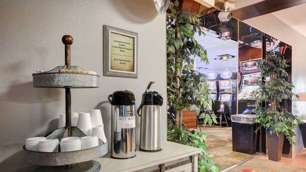 Eine Kaffeestation mit Kaffeemühle, Warmwasserbereitern und Einwegbechern.