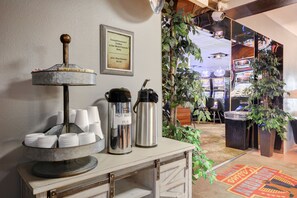 A coffee station with a coffee grinder, hot water bottles, and disposable cups. - Longhorn Casino & Hotel (Las Vegas)