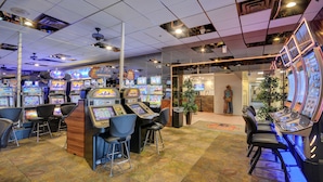 Ein Casino mit mehreren Spielautomaten und Barhocker.