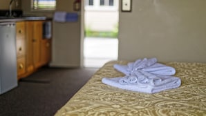 A hotel room with a bed, a bathroom, and a kitchenette. - Lantern Court Motel (Reefton)