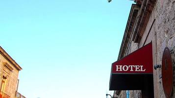 A hotel sign on a building with a clear blue sky in the background.