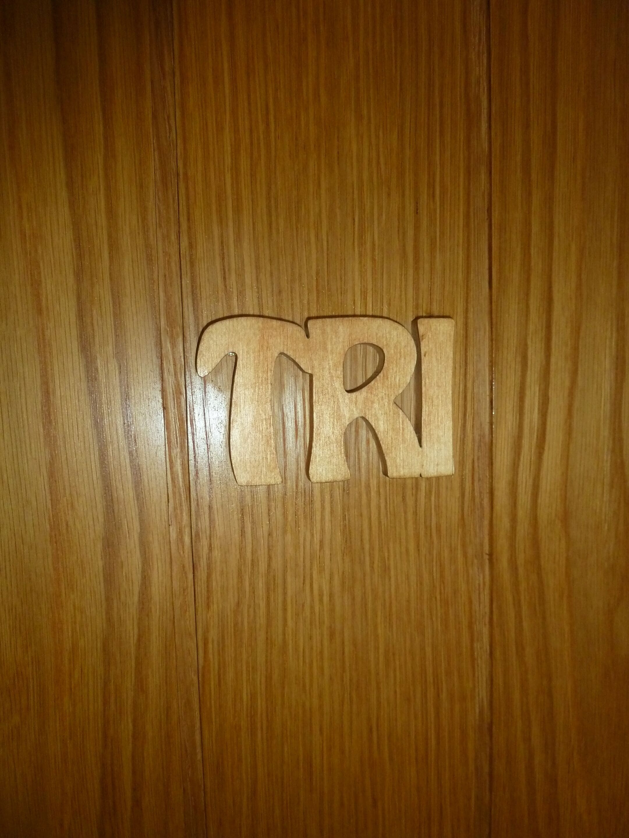 Una superficie de madera con las letras "TRI" talladas.