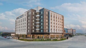 A multi-story hotel with a modern design, featuring a prominent 'Soda' sign on the facade.