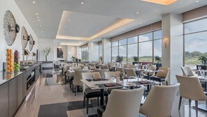 A spacious restaurant with high ceilings, large windows, and modern decor.