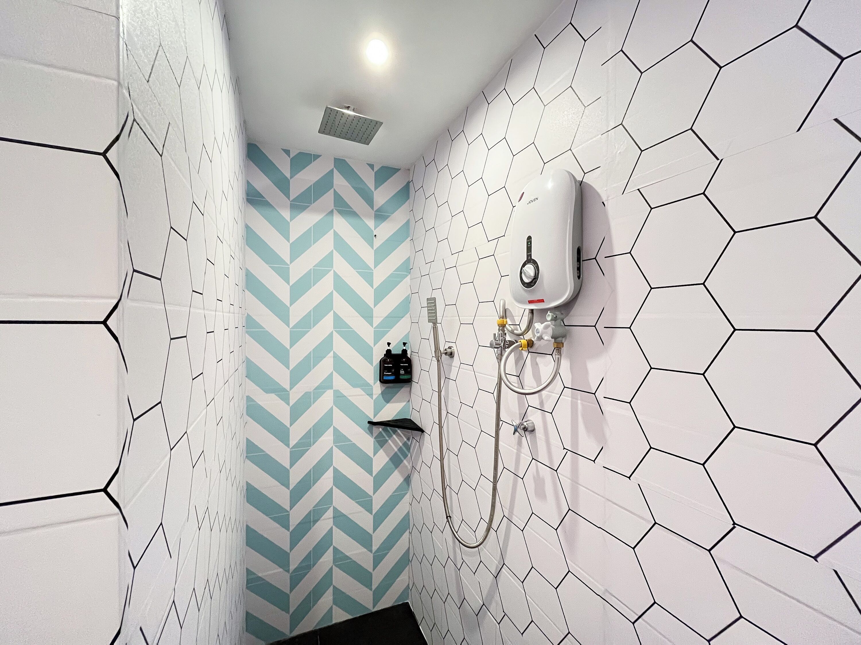 Un baño con ducha, secamanos y calentador de pared.