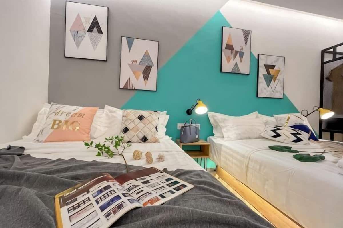 Un dormitorio moderno con cama, mesitas de noche y decoración en la pared.