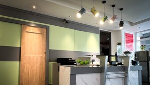 A modern kitchen with a wooden door, a marble countertop, and a built-in oven. - Apple 1 Hotel Queensbay (George Town)