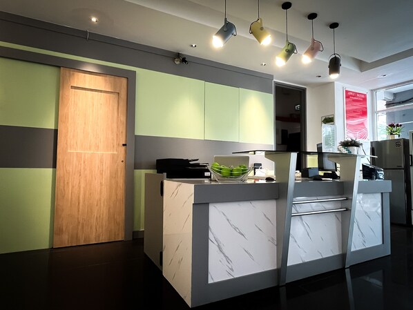 A modern kitchen with a wooden door, a marble countertop, and a built-in oven. - Apple 1 Hotel Queensbay (George Town)