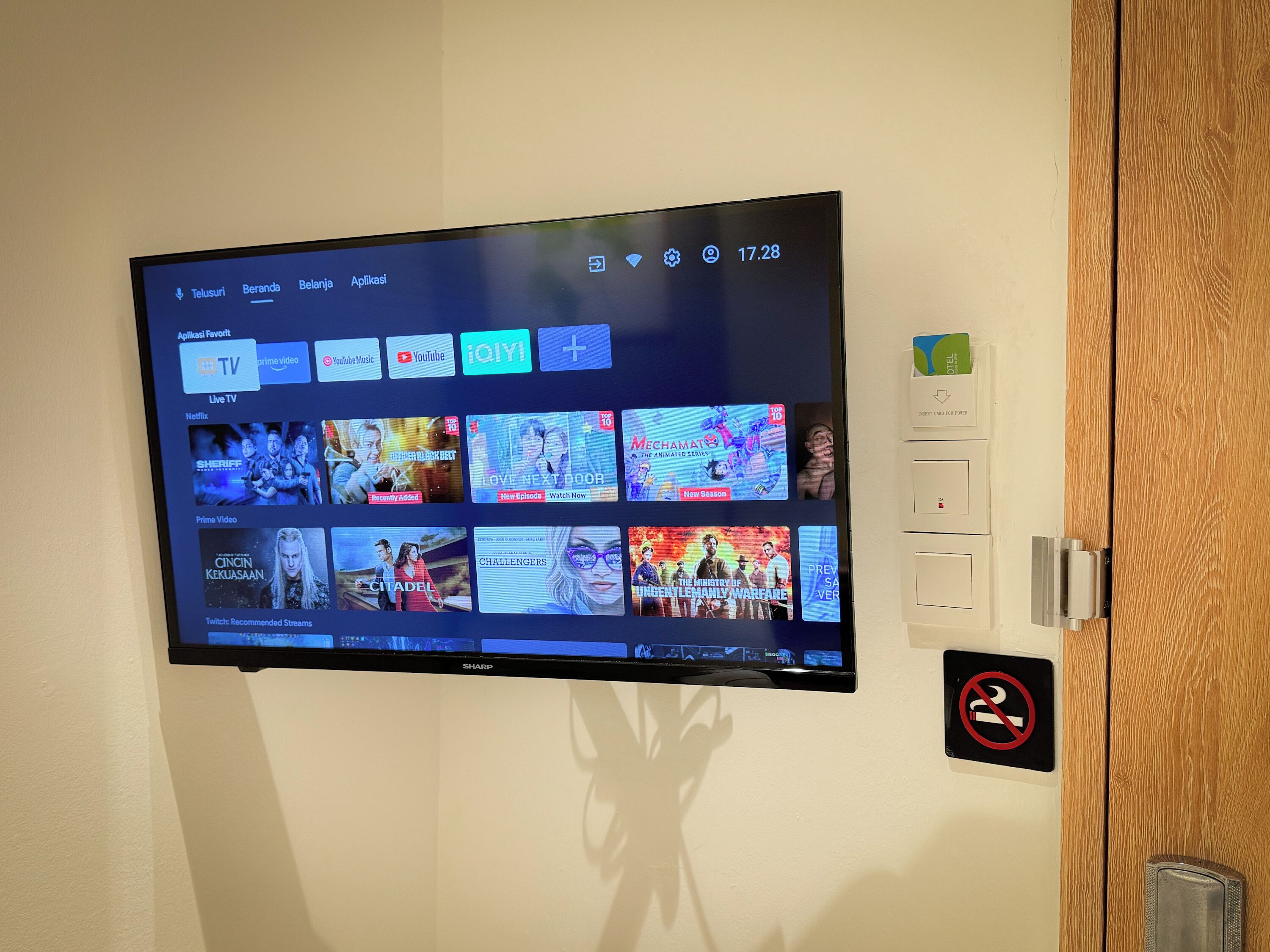 Een flatscreen-tv aan een muur, met diverse streamingdiensten en content.