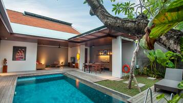 A modern house with a swimming pool, a dining area, and a kitchen.
