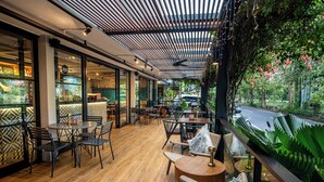 An indoor seating area with wooden flooring, tables, and chairs. - Abia Villa and Suite Legian (Legian)