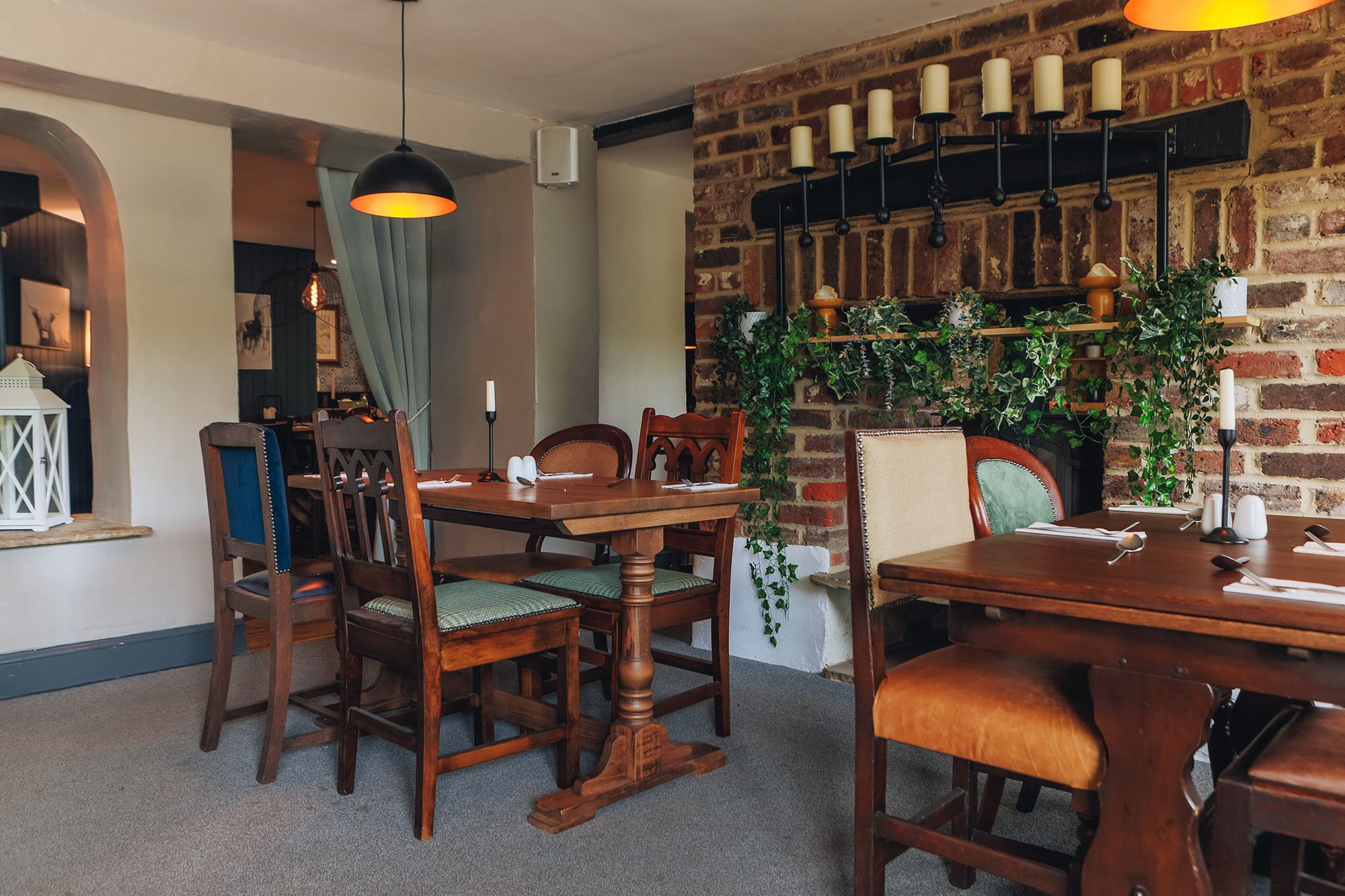 A dining area with brick walls, wooden tables, and chairs.