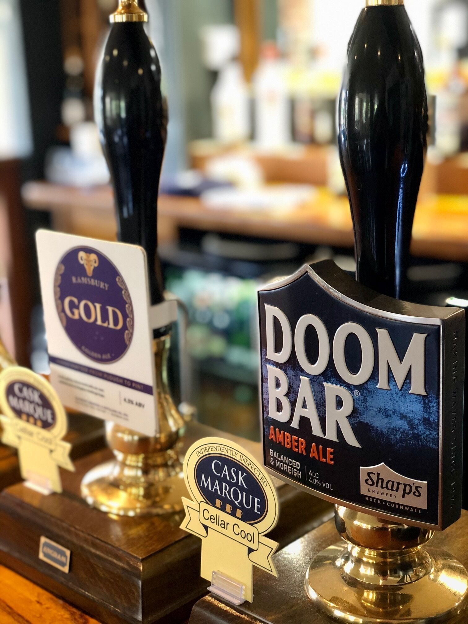 A bar with tap handles labeled 'Cask Marque' and 'Doom Bar Amber Ale'.