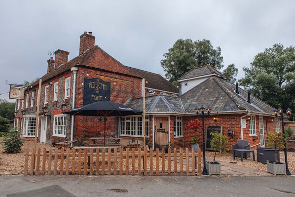 A traditional brick building with a sign reading "The Pelican Inn Food." - The Pelican Inn (Marlborough)