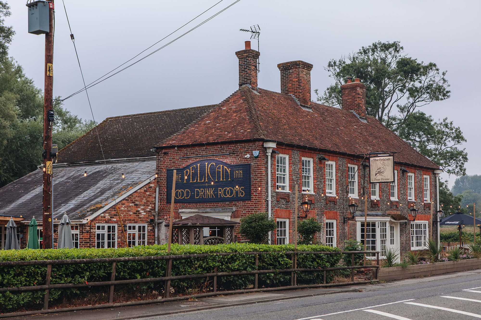 A traditional brick building with a sign for 'The Pelican Inn Food Rooms.'