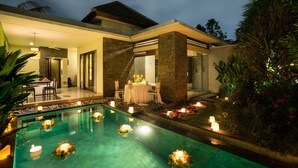 Ein modernes Haus mit Swimmingpool, Essbereich und überdachter Terrasse.