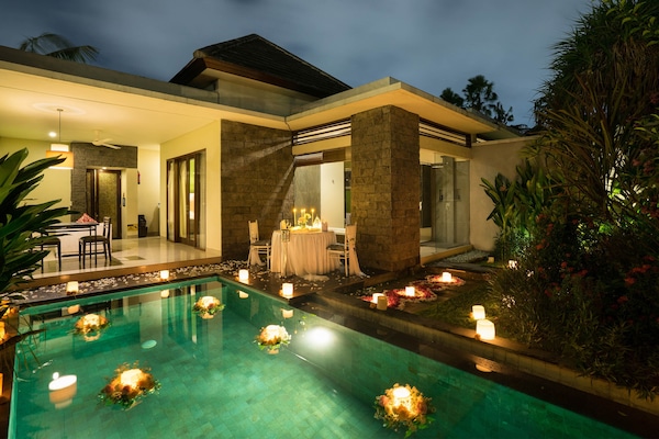 Una piscina al aire libre, sombrillas, tumbonas