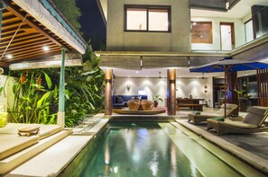 A pool area with lounge chairs, a sofa, and a dining table. - Pulau Boutique Villas (Kerobokan)
