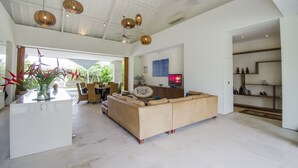 Un amplio salón con un sofá grande, una mesa de comedor y una isla de cocina.