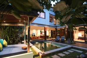 Une maison moderne dotée d’une piscine, d’un espace salon extérieur et d’une végétation luxuriante.