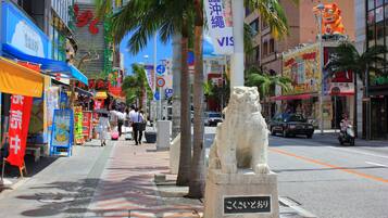 A busy urban street with a stone lion statue in the center.
