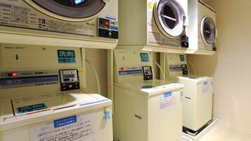 A row of coin-operated washing machines in a public facility.