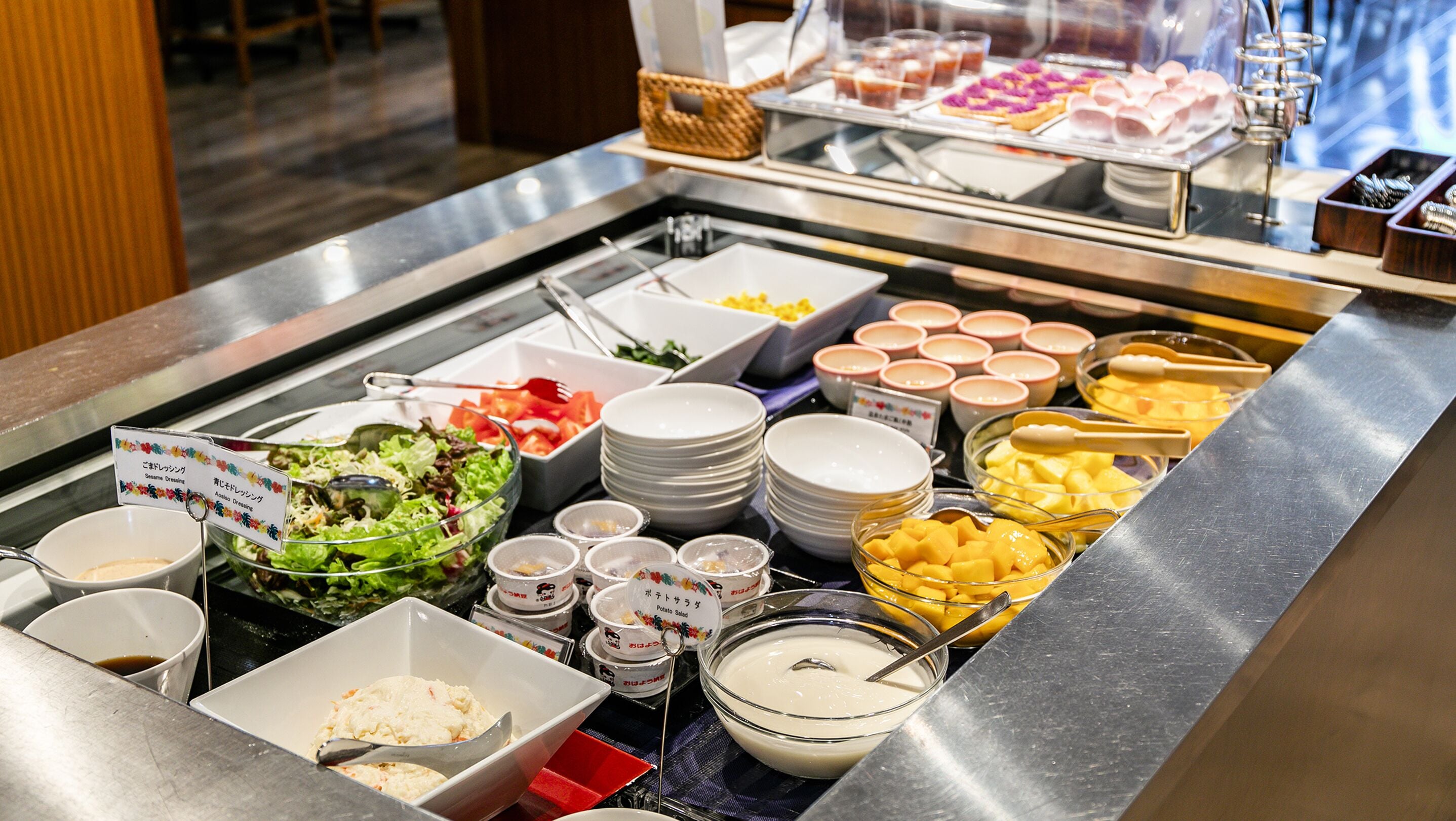 A buffet with various food options including salads, rice, and meats.