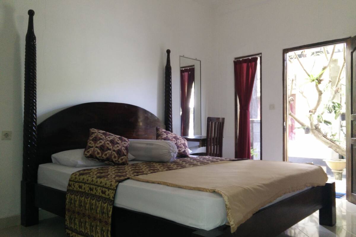 A bed with a headboard, pillows, and a blanket.