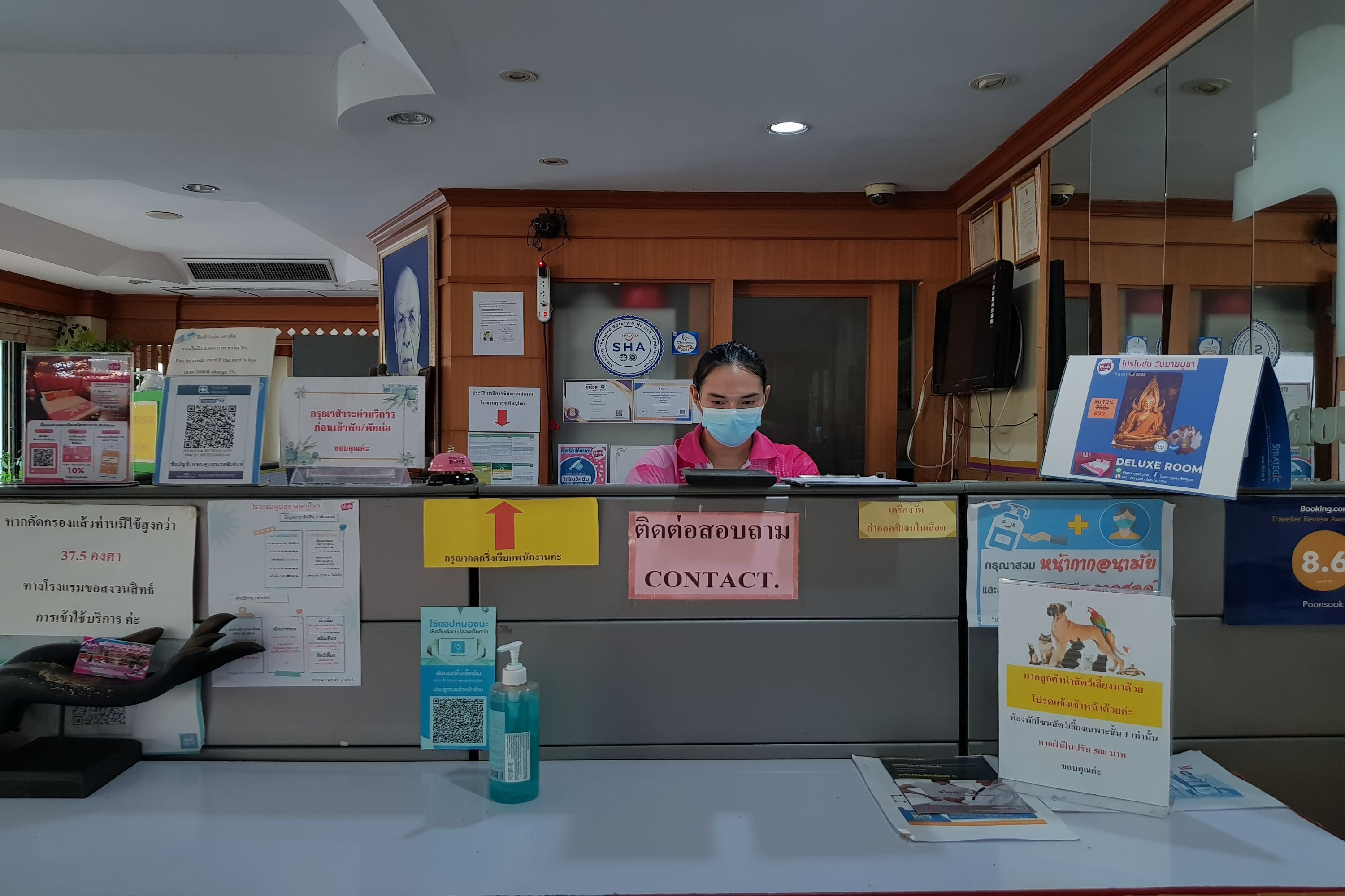 A reception desk with a sign reading "CONTACT." in front of it.