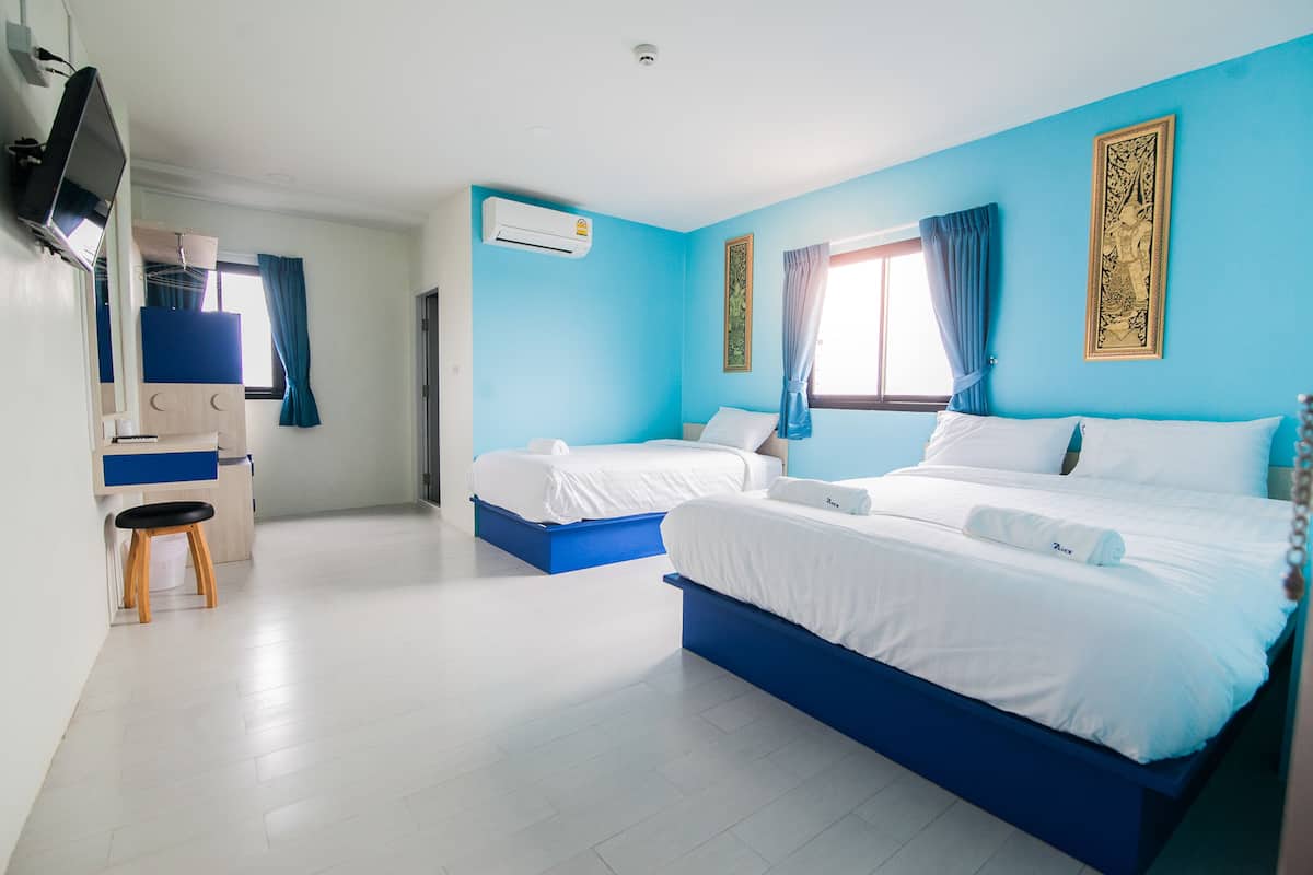 Una habitación de hotel con dos camas, un escritorio y una televisión.