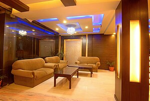 A modern living room with sofas, a coffee table, and a chandelier.