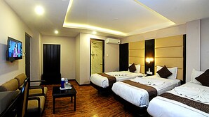Une chambre d’hôtel avec deux lits, une télévision, un bureau et une chaise.