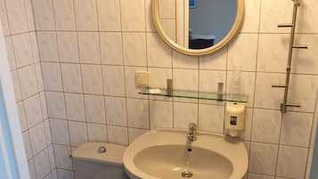 Ein kleines Badezimmer mit Toilette, Waschbecken und Spiegel.