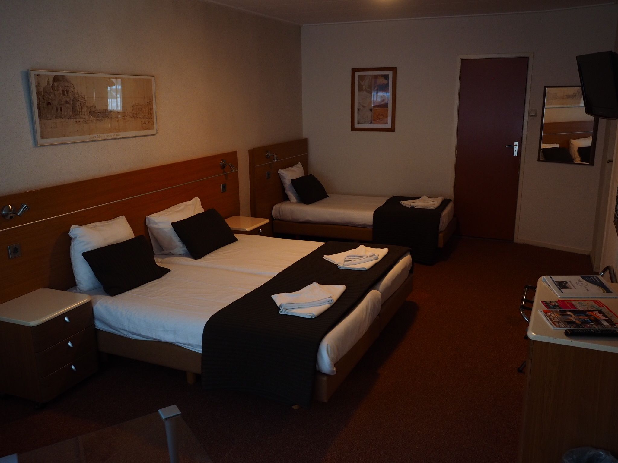 Una habitación de hotel con dos camas, un escritorio y una silla.