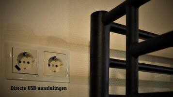 Toma de corriente empotrada con dos puertos USB y una etiqueta que indica 'Directe USB aansluitingen'.