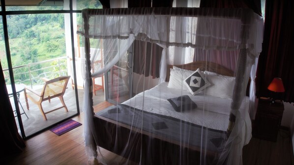 A bedroom with a canopy bed, a balcony with a chair, and a view of the outdoors. - Misty Hills Ella Resort (Ella)